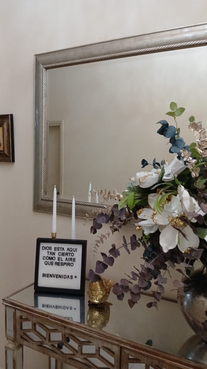 Arreglo floral junto a espejo decorativo